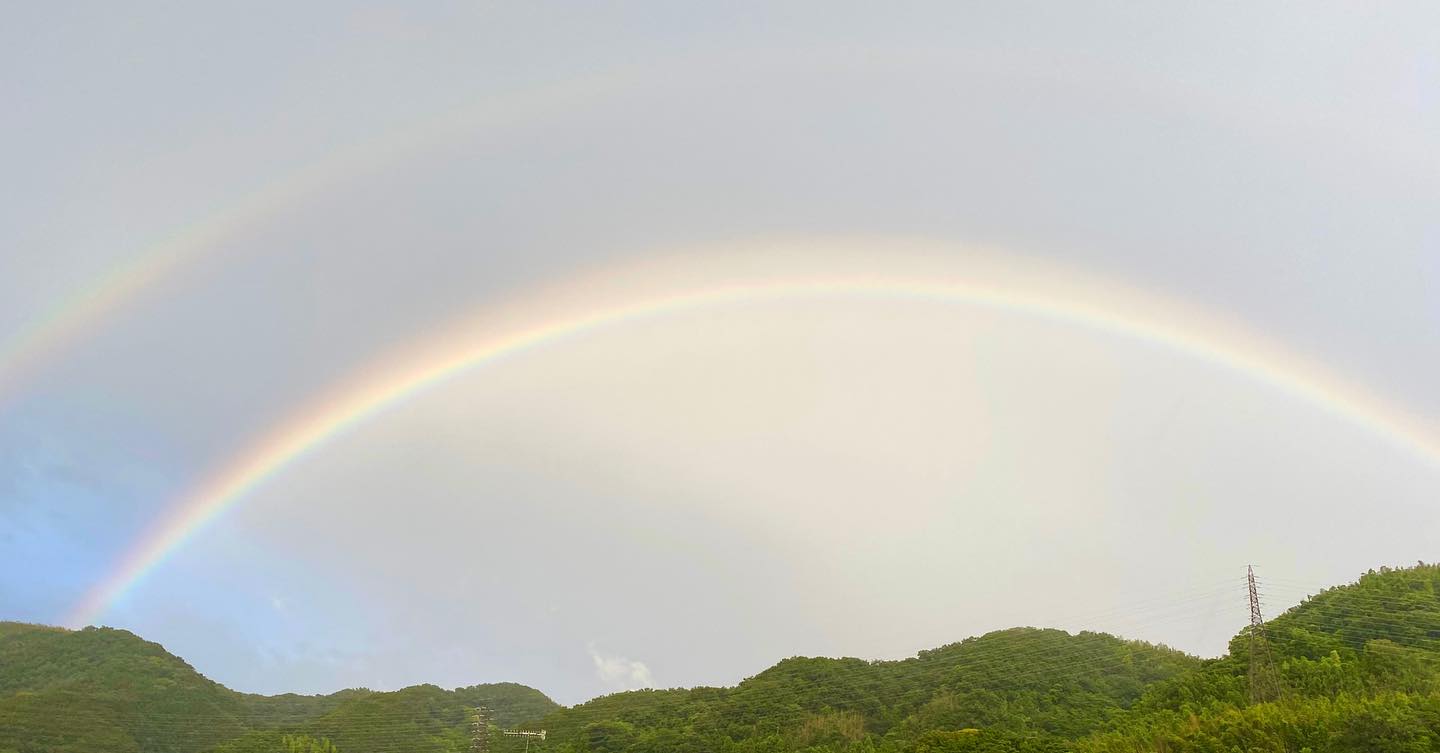 大きなダブルレインボー、見逃さなくてよかった(^^)階段を下りていたら踊り場の窓の外に、どーん！と。急いで海まで走って行って、山の方を向いて撮りました。雨風強めでしたが#ダブルレインボー #虹